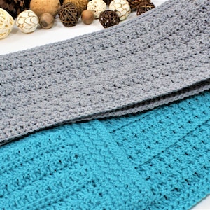May include: Two crocheted scarves, one gray with a pocket and one turquoise. Both scarves have a textured stitch pattern.