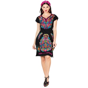 May include: A black short-sleeved dress with colorful embroidery. The dress has a V-neck and a floral pattern. The model is wearing a pink flower crown.