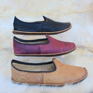 Pu&ograve; includere: Tre paia di scarpe in pelle da infilare in nero, bordeaux e marrone. Le scarpe hanno una punta a punta e una suola piatta.