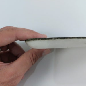 May include: Close-up of the edge of a white foam insole with a black trim.