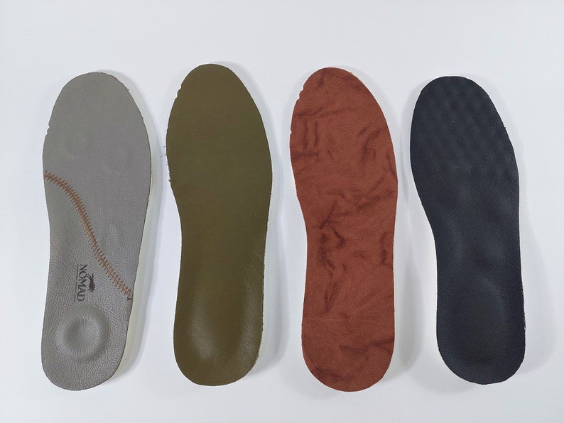 May include: Four different insoles for shoes. The insoles are made of different materials, including leather, suede, and foam. The insoles are all in the same shape and size. The insoles are all in different colors, including gray, green, brown, and black.