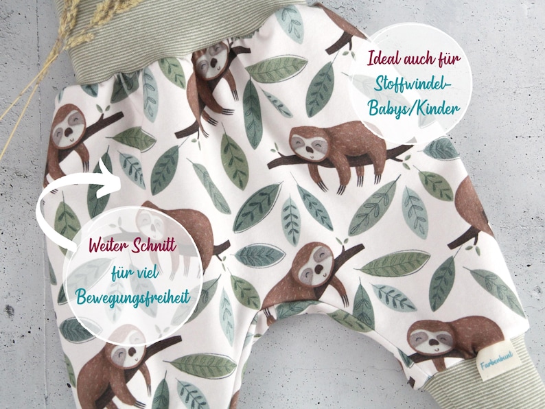 May include: Baby pants featuring a white background with a repeating pattern of brown sloths resting on branches and green leaves. The garment has a wide, ribbed olive green waistband and matching ribbed leg cuffs. A small white brand tag is visible.