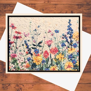 May include: A vintage-style greeting card featuring a colorful floral bouquet with pink, yellow, blue, and white flowers. The flowers are arranged in a field-like setting against a textured background.