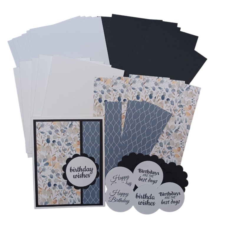 May include: A set of card making supplies featuring a blue and beige watercolor pattern with leaves and a geometric pattern. The set includes cardstock, patterned paper, and die-cut circles with birthday wishes.