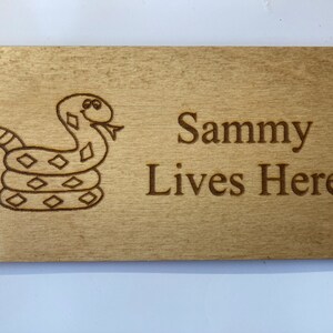 May include: A wooden sign with a cartoon rattlesnake and the text "Sammy Lives Here".
