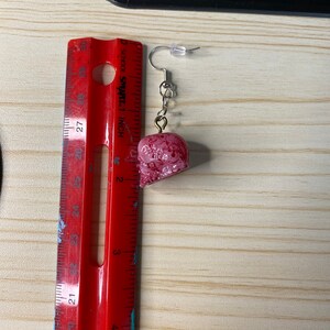 K&ouml;nnte beinhalten: Ein Paar rote und wei&szlig;e Totenkopf-Ohrringe mit silbernen Haken. Die Ohrringe sind etwa 2,5 cm lang.