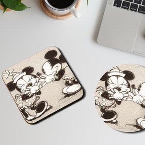 May include: A set of two black and white coasters featuring a vintage illustration of Mickey Mouse and Minnie Mouse. The coasters are made of wood and have a square and round shape.