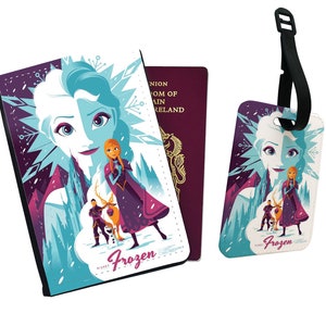 May include: A passport holder and luggage tag featuring a colorful illustration of Elsa and Anna from the Disney movie Frozen. The design includes a purple, blue, and white background with snowflakes and a mountain scene. The text "Frozen" is printed on both items.
