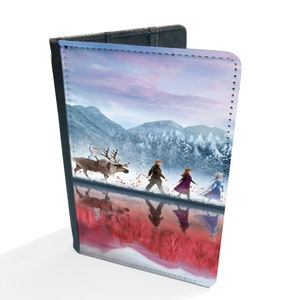 May include: A passport cover featuring a winter scene with a group of people walking through a snowy forest. The characters are from the movie Frozen II. The cover is made of a durable material and has a stitched edge.