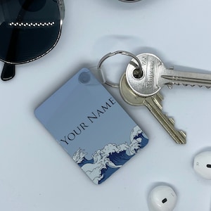 May include: A blue and white key chain with a wave design and the text "YOUR NAME".