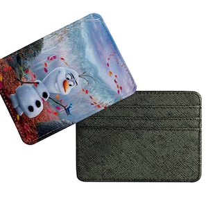 Puede incluir: Un porta tarjetas negro con una imagen colorida de Olaf de Frozen. La imagen muestra a Olaf de pie en un bosque nevado con hojas que caen.
