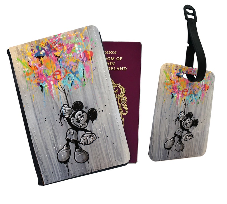 May include: A passport holder and luggage tag set featuring a colourful graffiti design with Mickey Mouse holding balloons. The background is a grey woodgrain pattern.