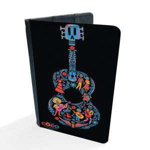 May include: Black passport holder with a colorful guitar design featuring a skull and characters from the Disney Pixar movie Coco. The text "Coco" is printed on the bottom of the holder.