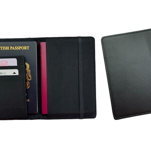 May include: Black leather passport holder with a built-in elastic strap and a separate pocket for cards. The holder is open to show a British passport, a credit card, and a burgundy passport.