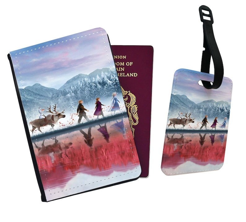 May include: A passport holder and luggage tag set featuring a winter scene with four figures walking on a frozen lake. The figures are walking in a line, with a reindeer and a snowman in front of them. The background is a snowy forest with mountains in the distance. The sky is a soft pink and blue.
