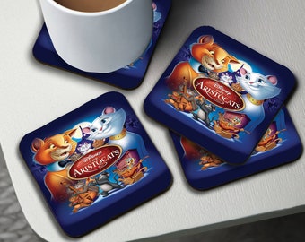 May include: Set of four blue square coasters featuring a Disney's The Aristocats design. The coasters feature the characters Duchess, Thomas O'Malley, and the kittens from the movie. The text "Disney's The Aristocats" is printed on the coasters.