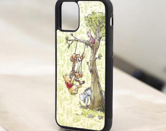 May include: A black phone case with a Winnie the Pooh design. The case features Winnie the Pooh, Tigger, and Piglet on a swing in a tree. The background is a light green with a pattern of small trees.