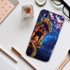 May include: A phone case with a colorful illustration of a princess with long blonde hair looking out from a tower. The background is a dark blue sky with floating lanterns.