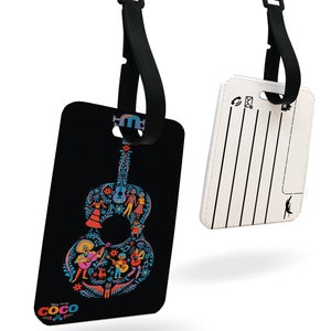 May include: Black luggage tag with a colorful guitar design featuring characters from the Disney Pixar movie Coco. The tag has a black strap with a buckle. The back of the tag is white with a blank space for writing.