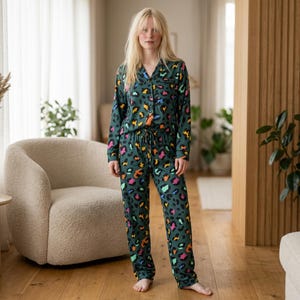 May include: Green pajama set with a colorful leopard print. The set includes a button-down shirt and drawstring pants. The pajamas are made of a soft material and are suitable for lounging.