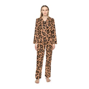 May include: A two-piece pajama set featuring a brown and black leopard print. The long-sleeved top has a collared neckline and button-down closure. The matching pants have a relaxed fit. The pajamas are made of a soft material.
