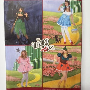 Puede incluir: Patrón de costura Simplicity 2547 para disfraces de El Mago de Oz en talla FF 18W-24W. El paquete muestra cuatro diseños de disfraces distintos, incluyendo una bruja, un vestido azul y blanco, un vestido rosa con estrellas y un traje colorido.