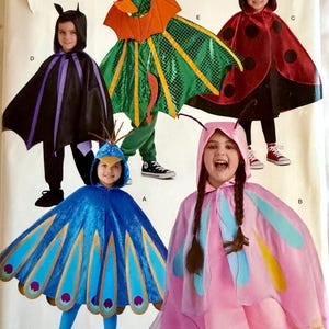May include: A Simplicity sewing pattern envelope H0204 featuring five costume designs: a black bat cape, a green dragon cape with orange wings, a red ladybug cape with black spots, a blue peacock cape with gold trim, and a pink butterfly cape.