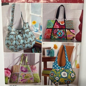 Op de afbeelding: Een Simplicity 0483 naaipatroon-envelop voor Sweet Pea Totes met vier tasontwerpen. De afbeeldingen tonen diverse draagtassen met bloemen- en geometrische patronen, waaronder geplooide stijlen met knoopsluitingen en rechthoekige patchworktassen.