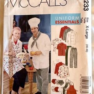 May include: A McCall's M2233 sewing pattern envelope for Uniform Essentials in size X-Large (46-48). The front features illustrations of chef uniforms including jackets, pants, aprons, and hats, with a photo of two people wearing the garments.