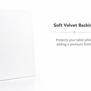 Op de afbeelding: Een rechthoekig wit object met een getextureerd oppervlak, geplaatst naast de tekst Soft Velvet Backing, Protects your table while adding a premium finish. Het object heeft een strak uiterlijk en een solide, rechtopstaande structuur.
