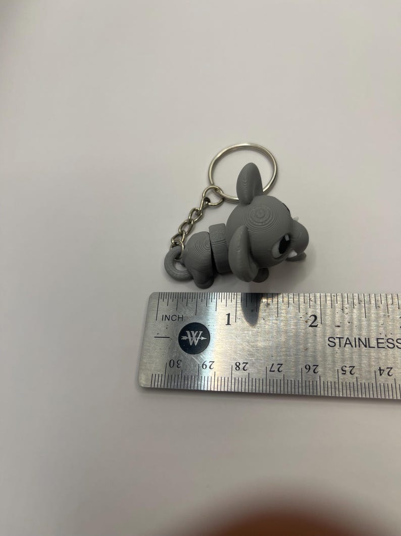 May include: A gray, 3D printed mouse keychain with a silver chain and ring. The mouse is about 1 inch long.