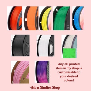 May include: A selection of 3D printer filament spools in various colours: orange, yellow, green, blue, black, white, pink, and purple. Text reads, "Any 3D printed item in my shop is customisable to your desired colour!" and "Astra Studios Shop."