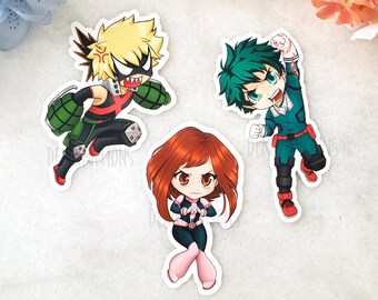 May include: Three cartoon character stickers featuring a green and black character with spiky green hair, a red and black character with spiky yellow hair, and a red-haired character with a pink and black outfit.