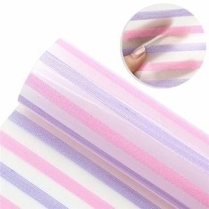 May include: A roll of white vinyl with alternating pink and purple stripes. The vinyl has a subtle glitter finish.