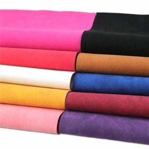 May include: A stack of colorful faux suede fabric sheets in various shades of pink, red, brown, blue, burgundy, and purple.