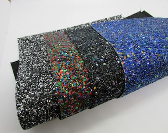 May include: Four rolls of glitter fabric in black, red, green, and blue. The fabric is covered in small, iridescent glitter.