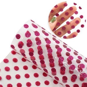 May include: Pink glitter polka dot patterned vinyl sheet. The sheet is transparent and has a subtle shimmer.