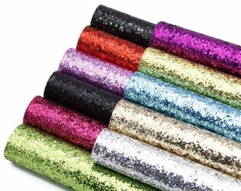 May include: A collection of ten rolls of glitter fabric in various colors, including green, silver, gold, blue, black, pink, purple, red, and dark green. The fabric is made of a soft, sparkly material and is perfect for crafting projects.