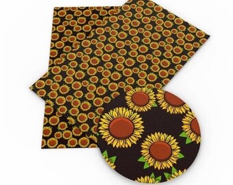 May include: A sheet of black faux leather with a sunflower pattern. The sheet is cut into a circle and a rectangle. The sunflowers are yellow with brown centers and green leaves.