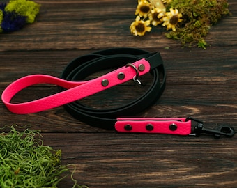Peut inclure: Ensemble laisse et collier pour chien noir et rose vif. La laisse noire est ornée d'une poignée et d'éléments roses vifs. Les parties roses vives présentent un motif texturé et sont fixées par des rivets noirs. Comprend un attache-collier assorti.