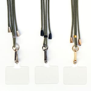 K&ouml;nnte beinhalten: Drei gr&uuml;ne Lanyards mit verschiedenen farbigen Metallschlie&szlig;en und durchsichtigen Plastik-Ausweishaltern.