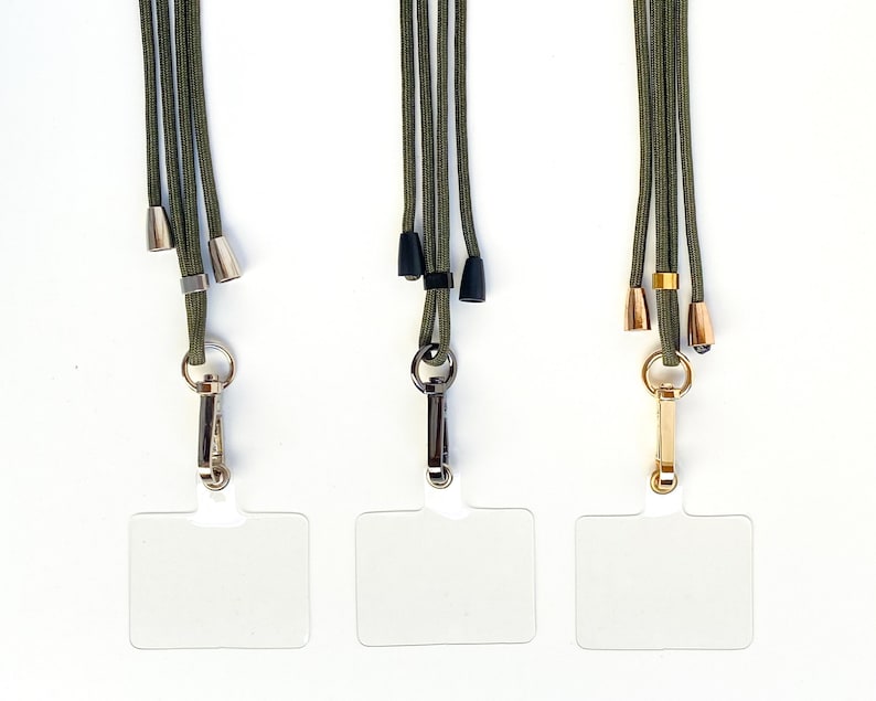 K&ouml;nnte beinhalten: Drei gr&uuml;ne Lanyards mit verschiedenen farbigen Metallschlie&szlig;en und durchsichtigen Plastik-Ausweishaltern.