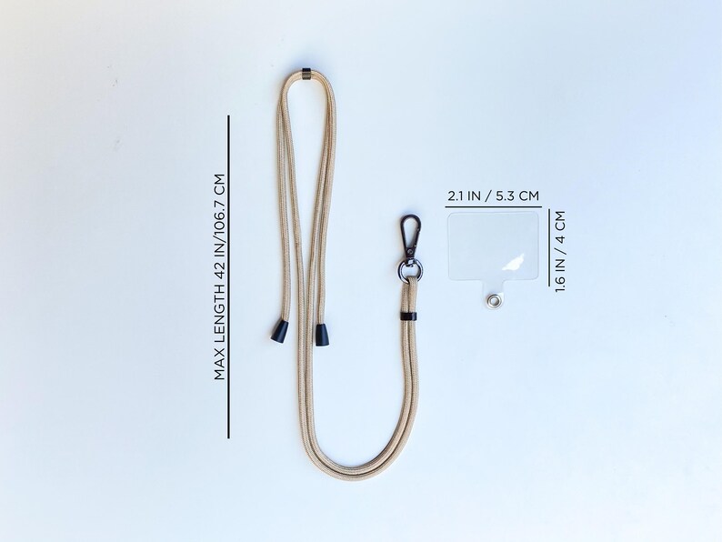 K&ouml;nnte beinhalten: Ein beiger Lanyard mit schwarzen Endkappen und einem durchsichtigen Plastik-Badgehalter. Das Lanyard ist 106,7 cm lang und der Badgehalter ist 5,3 cm breit und 4 cm hoch.