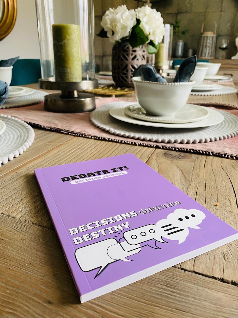 May include: Purple journal with the title "Debate It! Decision Journal" and the text "Decisions determine destiny" with speech bubbles.