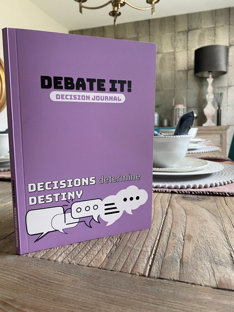 May include: Purple journal with the title "Debate It! Decision Journal" and the text "Decisions determine Destiny" with three speech bubbles.