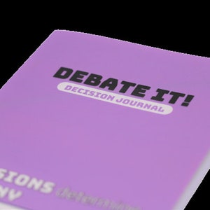 May include: A purple journal with the title "Debate It! Decision Journal" on the front cover. The journal has the words "Decisions Destiny" printed on the bottom of the cover.