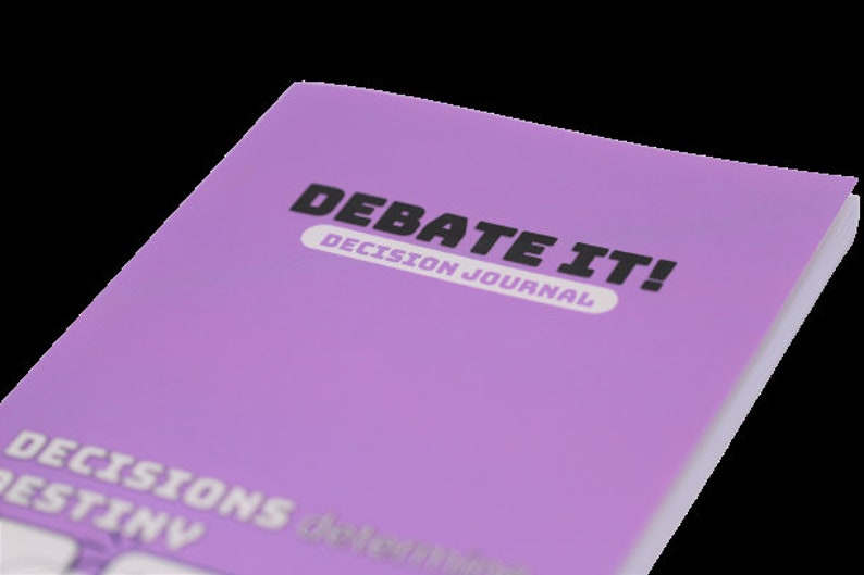 May include: A purple journal with the title "Debate It! Decision Journal" on the front cover. The journal has the words "Decisions Destiny" printed on the bottom of the cover.