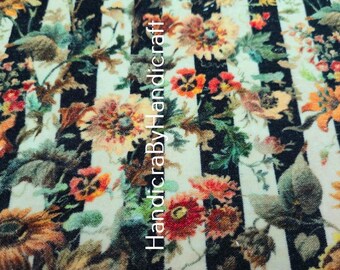 May include: Floral fabric with a striped background. The fabric features a repeating pattern of colorful flowers in shades of orange, red, and yellow, set against a backdrop of black and white stripes. The text "HandicraByHandicraft" is visible.