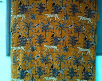 May include: Mustard-colored fabric with a repeating pattern of leopards, zebras, birds, and palm trees. The design features white leopards with black spots, zebras, toucans, and storks set against a backdrop of stylized palm trees and foliage.