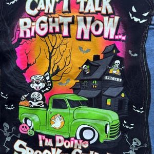 May include: A black patch with a Halloween-themed design. The patch features a green truck with a ghost, a skeleton, and a haunted house. Text on the patch reads "Can't Talk Right Now... I'm Doing Spooky Stuff."